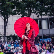 Lady with red parasol singing at Opera in the Open