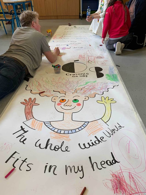 Children and adults creating poster together